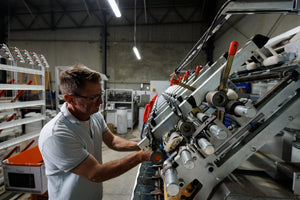 Photo shows Nick at the spinning frame, operating the spinner.