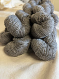 5 skeins on a table with a calico cloths showing the colour of the yarn