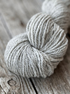 A light grey coloured skein is laying on a table 