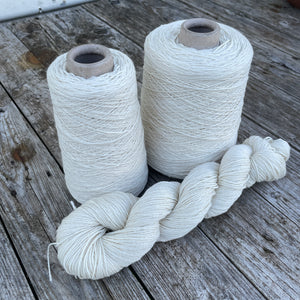 picture shows 2 cones of yarn and a single skein